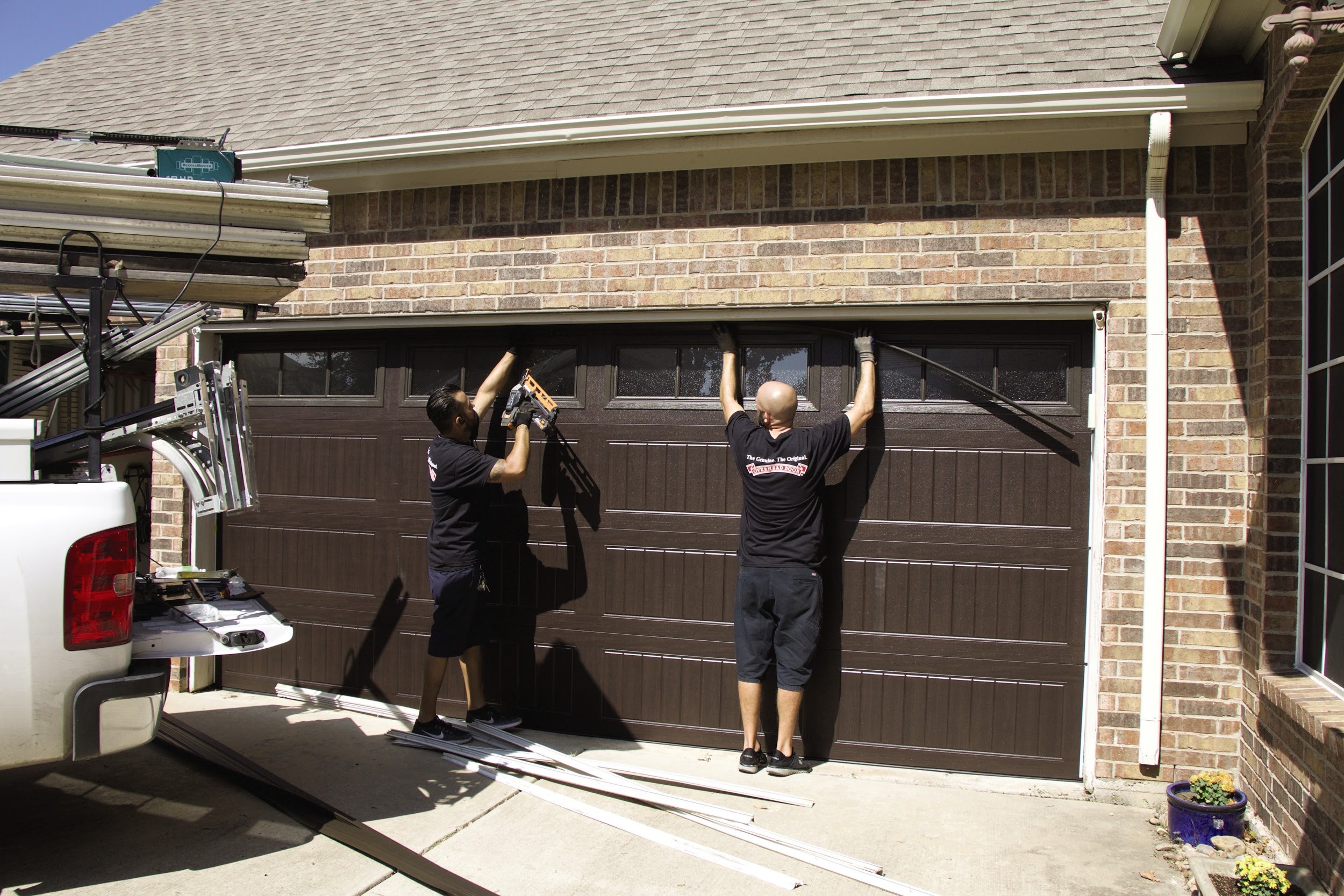 overhead door installers working on a garage door