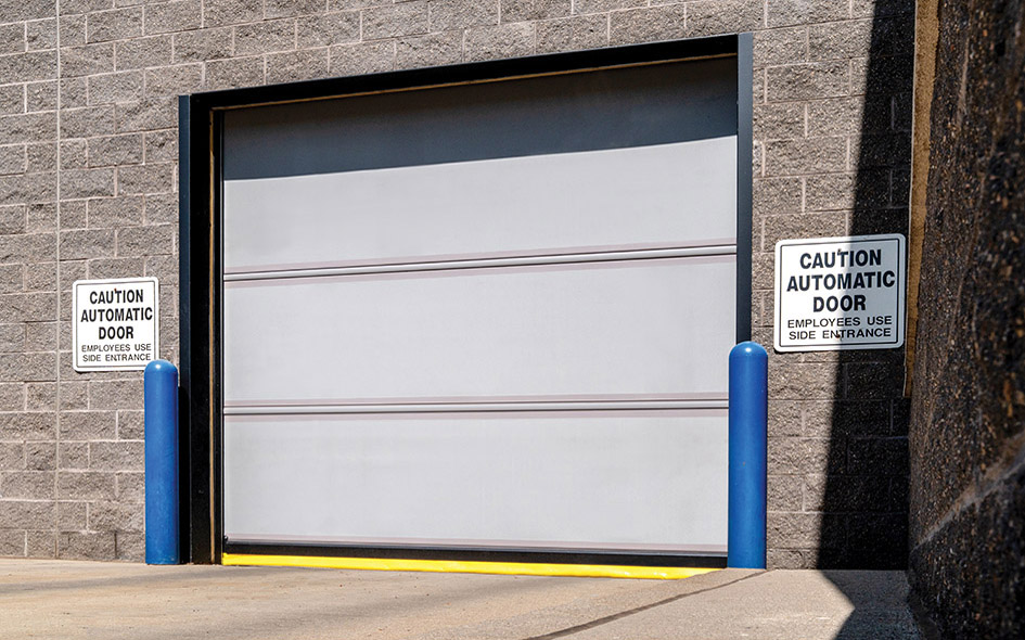 gray commercial door on a building with blue poles on each side