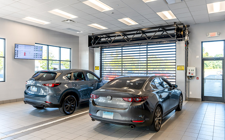 two cars parked in front of a commercial door