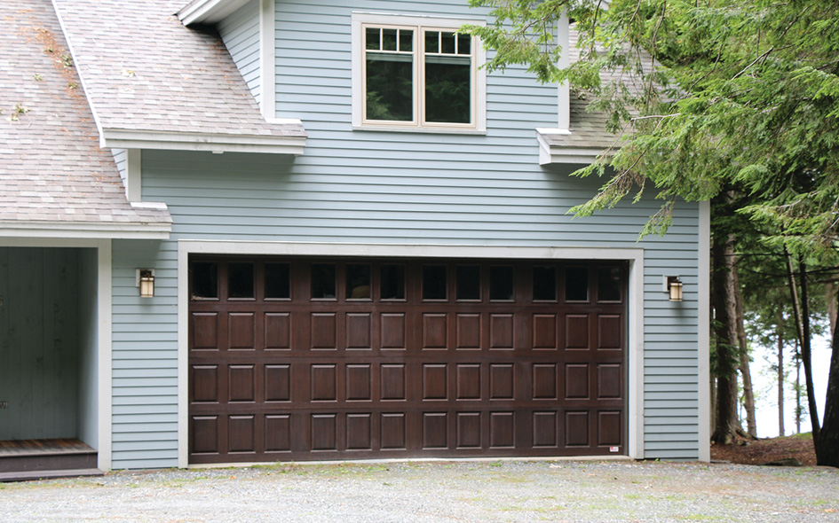 walnut fiberglass garage door on blue home